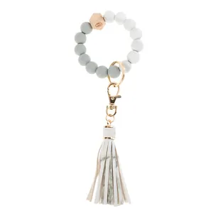 Detail of beaded wristlet keychain with marble silicone beads, wood bead, and tassel