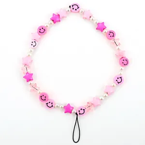 Detailed macro view of colorful beads, pink stars and smiley faces on a phone wrist strap