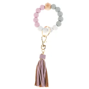 Close-up of pink and grey silicone beaded keychain with wooden bead and purple tassel