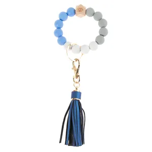 Detailed shot of beaded wristlet keychain with engraved wood bead and blue tassel