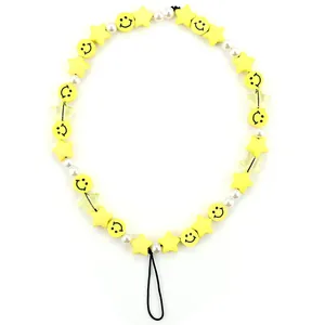 Detail of beaded phone strap with yellow smiley face, stars and white faux pearls