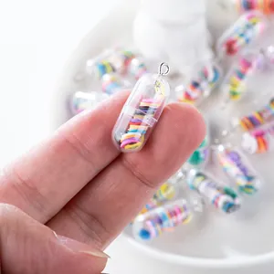Macro shot of creative transparent pill pendant with colorful charms and silver metal ring