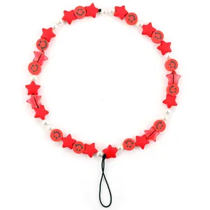 Detail of red star and smiley face beads with white faux pearls on phone lanyard