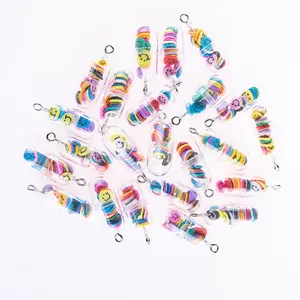Close-up of DIY capsule pendants with colorful smiley faces and silver metal hooks