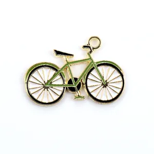 Close-up of green enamel bicycle pendant with golden alloy frame for DIY jewelry
