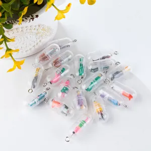 Detailed view of colorful miniature figures inside transparent pill-shaped capsule pendants