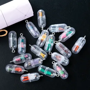 Macro shot of colorful pill capsule pendants with miniature figures on black background