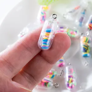 Macro view of transparent pill capsule pendant filled with colorful clay slices