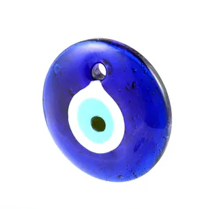 Detail of blue glass evil eye pendant featuring smooth texture and centered charm hole