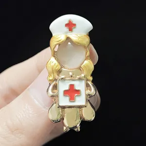Detail of angel nurse brooch with gold plating, white enamel and red cross symbol