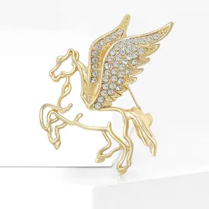 Elegante spilla Pegasus dorata con strass bianchi su supporto per esposizione