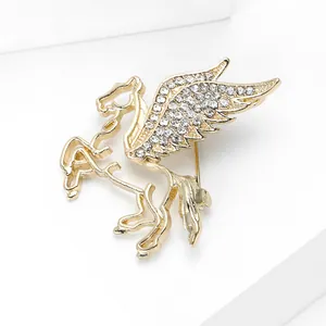 Macro della spilla a forma di pegaso dorato con strass bianchi brillanti pavé