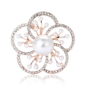 Broche fleur élégante en or rose avec perle centrale et strass sur fond blanc