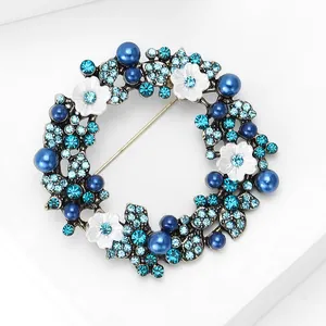 Nahaufnahme der Luxus-Kranzbrosche mit blauen Strasssteinen und weißen Perlen