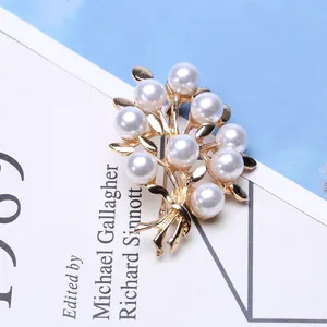 Elegant gold pearl brooch featuring a floral branch design with 10 lustrous pearls