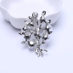 Back view of silver branch brooch with pearls showing pin clasp and metal texture