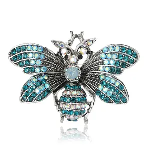 Exquisite silver alloy bee brooch with teal rhinestones shown on a white background