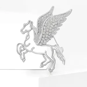 Spilla Pegasus in argento traforato con ali di cristallo su sfondo bianco minimalista