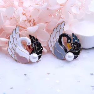 Elegante set de broches de cisne con perlas y cristales sobre fondo de tul decorativo