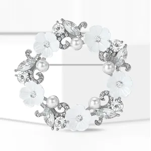Détail macro d'une broche couronne argentée avec perles et strass étincelants