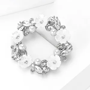 Détail macro d'une broche couronne de fleurs de luxe avec strass et perles blanches