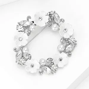 Détail macro d'une broche couronne florale de luxe avec perles blanches et strass brillants