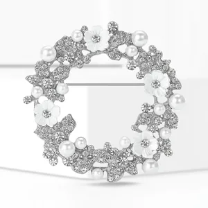 Detailansicht einer silbernen Kranzbrosche mit Strasssteinen, Perlen und Blumen