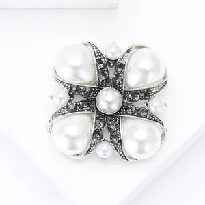Detailed view of Baroque cross brooch with teardrop pearls and gray rhinestones