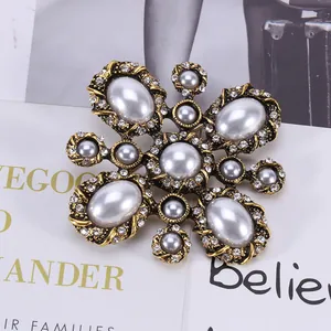 Macro shot of vintage baroque cross brooch with white pearls and sparkling rhinestones