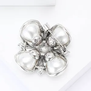 Detailed back view of vintage silver floral brooch with pearls and secure safety pin