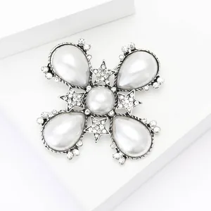 Macro detail of Baroque pearl brooch featuring silver stars and white teardrop pearls