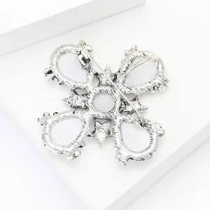 Detailed back view of vintage silver cross brooch featuring pearl insets and safety pin clasp