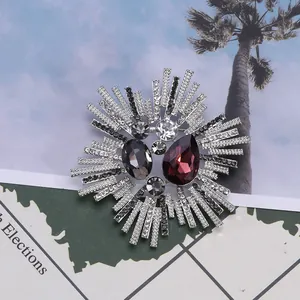 Detail of starburst brooch with red-brown teardrop crystal and silver plating