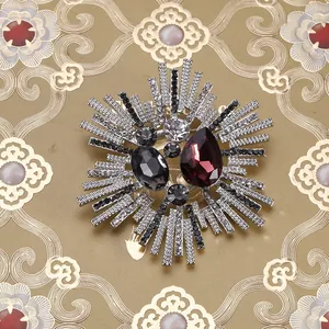 Macro shot of vintage starburst brooch with red waterdrop crystal and rhinestones
