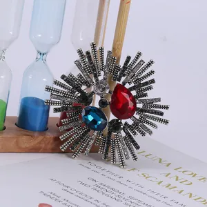 Vintage sunburst brooch with red teardrop stone and silver alloy sun rays