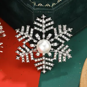 Macro detail of snowflake brooch with crystal rhinestones and large center pearl