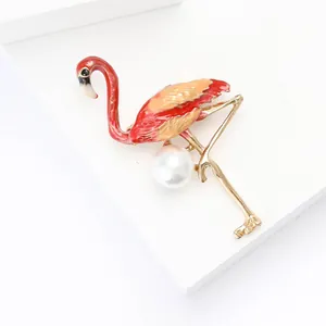 Broche flamant rose en alliage avec émail et perle blanche sur fond blanc minimaliste