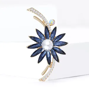 Broche fleur luxueuse avec cristaux bleus, perle blanche et finition dorée
