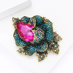 Vintage gold alloy flower brooch with blue rhinestones and pink teardrop stone