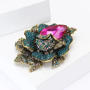Detailed close-up of a vintage floral brooch with multicolored rhinestones and pink crystal