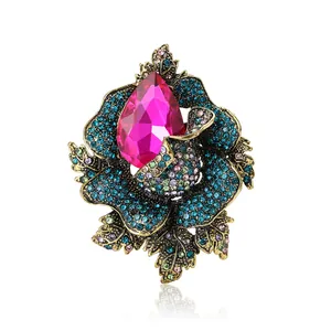 Vintage gold flower brooch featuring a large rose pink crystal and colorful rhinestones