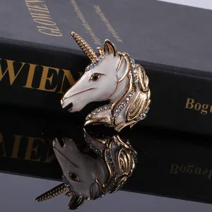 Vintage unicorn brooch with white enamel and colorful rhinestones on a golden base