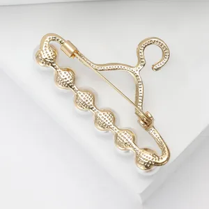 Broche élégante en forme de cintre doré avec six perles et strass scintillants