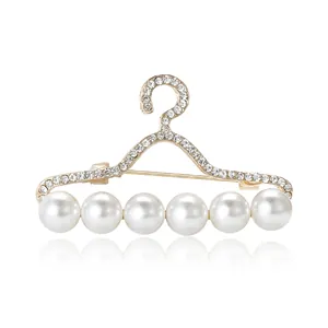 Broche élégante en forme de cintre doré avec strass brillants et six perles rondes