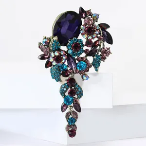 Detailansicht der Vintage Blumenbrosche mit bunten Strasssteinen und goldenen Quasten