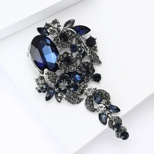 Detailansicht der Vintage Blumenbrosche mit großem dunkelblauem Kristall und Strass