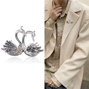 Broche double cygne élégante avec incrustation de cristaux et émail gris sur veste