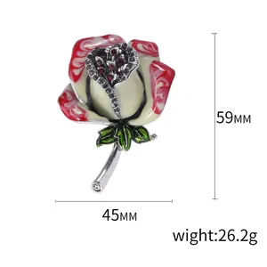 Spilla a bouquet di rose vintage con cristalli rossi e foglie in smalto verde su fondo bianco