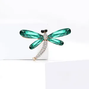 Elegante spilla a libellula con ali di cristallo verde e strass bianchi su base oro