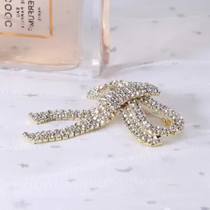 Close-up of golden bow brooch with sparkling rhinestones and elegant tassels